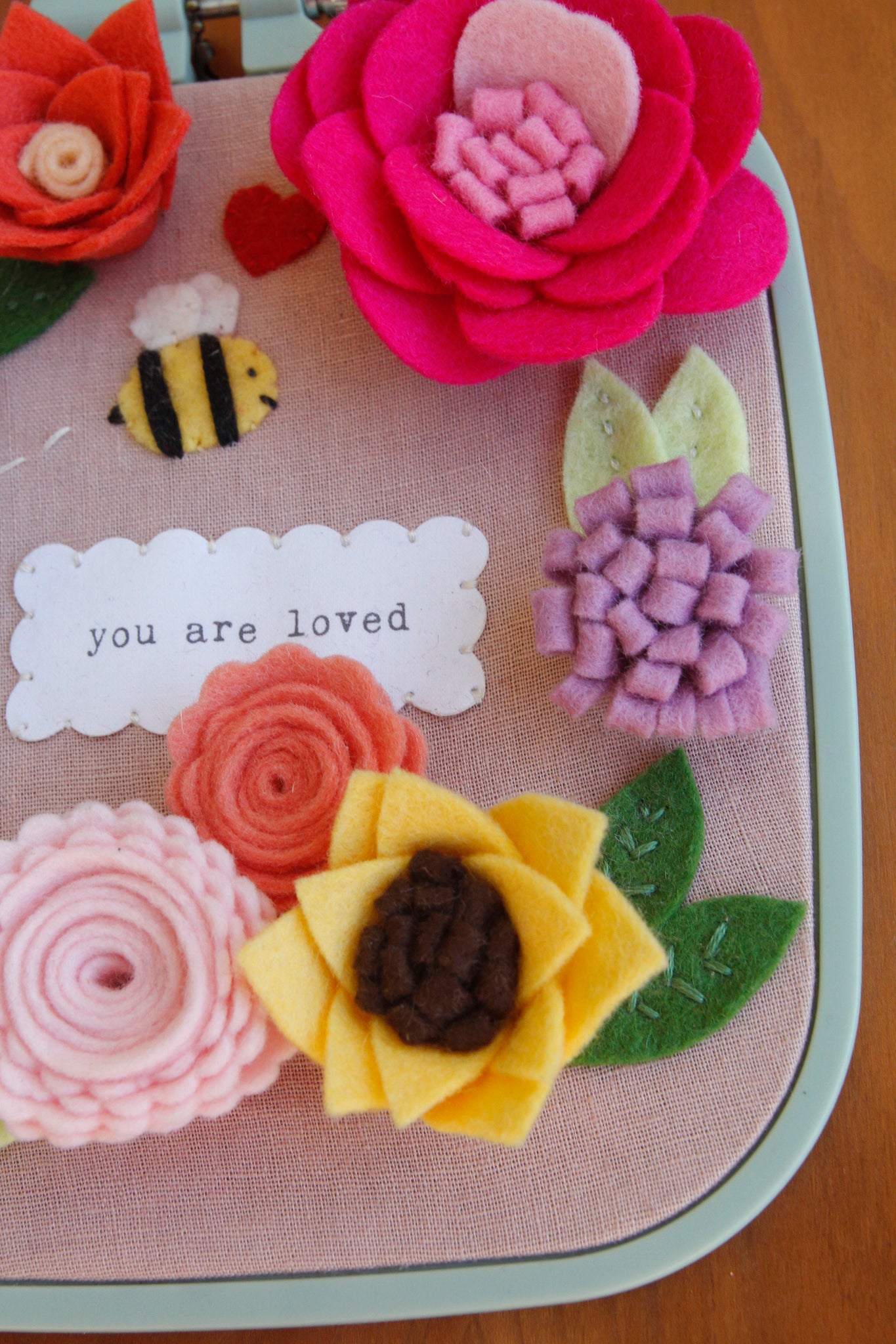 you are loved" original embroidered wall art with handmade felt flowers and bee